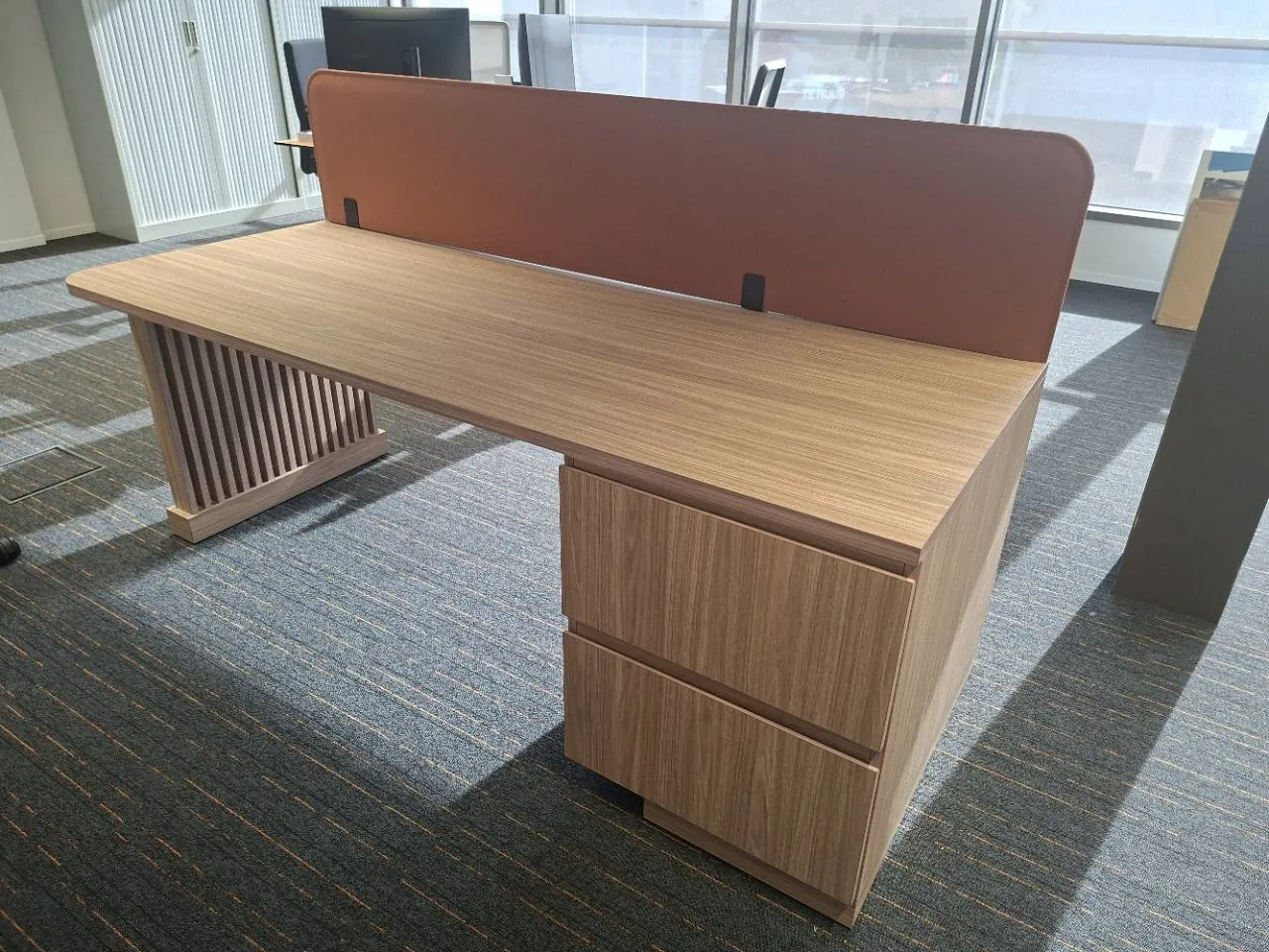 Foto van het gerealiseerde Bureau Duo met houten werkblad, scheidingspaneel, ladeblok en onderstel met verticale delen.